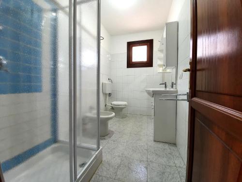 a bathroom with a shower and a toilet and a sink at Villette Miramare in Budoni