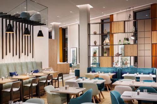 a dining room with tables and chairs and tablesktop at Holiday Inn - Hamburg - HafenCity, an IHG Hotel in Hamburg