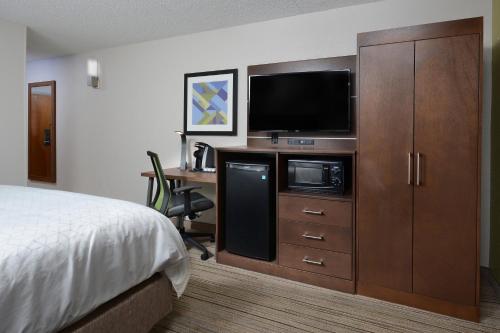 a hotel room with a bed and a desk with a television at Holiday Inn Express Danville by IHG in Danville