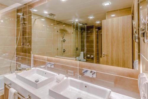 a bathroom with two sinks and a large mirror at Holiday Inn Ulaanbaatar by IHG in Ulaanbaatar