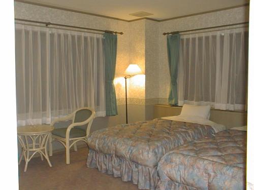 a hotel room with a bed and a table and chairs at il Regalo イルレガーロ in Kitashiobara