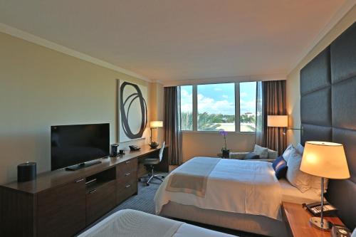 a hotel room with a bed and a flat screen tv at InterContinental At Doral Miami by IHG in Miami