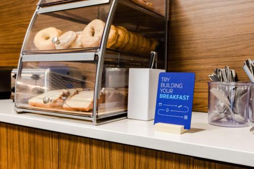 a shelf with donuts and a sign on it at Holiday Inn Express & Suites - West Edmonton-Mall Area by IHG in Edmonton
