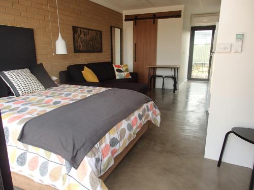 um quarto com uma cama e uma sala de estar com um sofá em Wahgunyah Motel em Wahgunyah