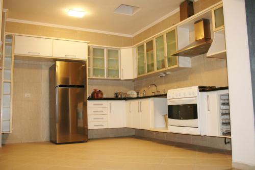 uma cozinha com armários brancos e um frigorífico de aço inoxidável em Viva Hostel Design em São Paulo