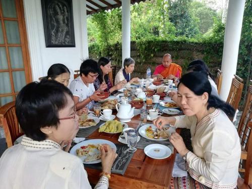 a group of people sitting around a table eating food at The European Gate - Anuradhapura in Anuradhapura