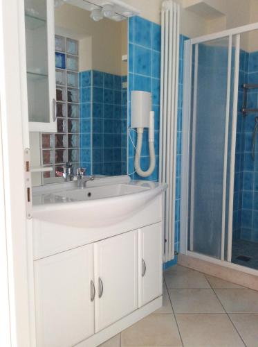 La salle de bains est pourvue d'un lavabo blanc et d'une douche. dans l'établissement Rosa Dei Venti, à Lugo