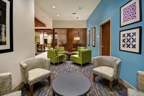 a waiting room with green chairs and a table at Holiday Inn Express & Suites - Galveston Beach, an IHG Hotel in Galveston