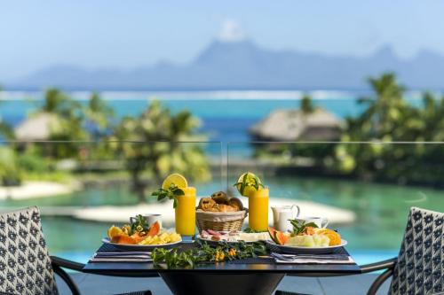 a table topped with plates of food and drinks at InterContinental Tahiti Resort & Spa, an IHG Hotel in Faaa