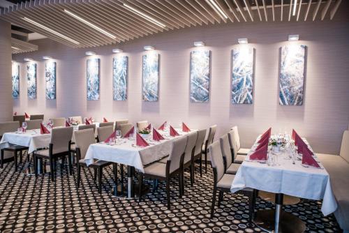 a dining room with tables and chairs with red napkins at Holiday Inn Dąbrowa Górnicza-Katowice by IHG in Dąbrowa Górnicza