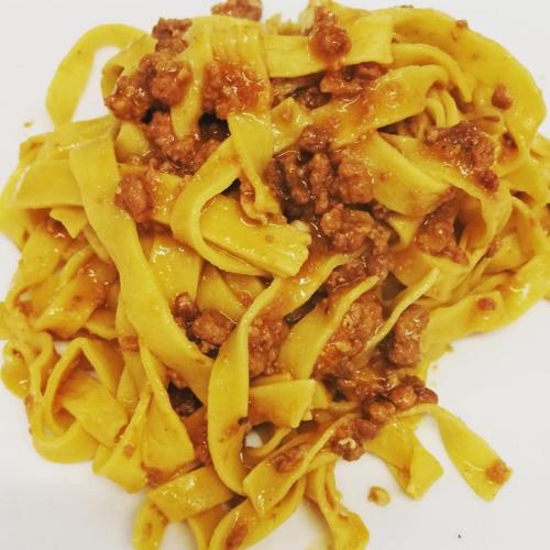 a pile of pasta with meat and cheese on a white plate at Rosa Dei Venti in Lugo