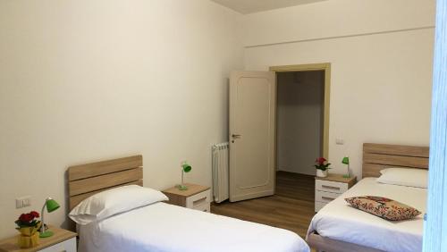 a room with two beds and a door to a hallway at EApartmentsfoligno in Foligno