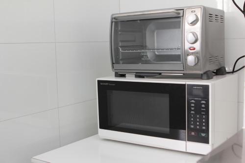 a microwave and a toaster oven sitting on top thereof at Haus Accommodation - note - Valid passport required to check-in in Perth