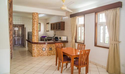 une cuisine avec une table et des chaises dans une pièce dans l'établissement Nyali Beach Holiday Resort, à Nyali