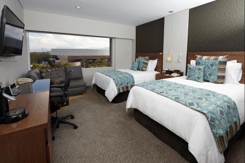 a hotel room with two beds and a desk at Presidente InterContinental Mexico City by IHG in Mexico City