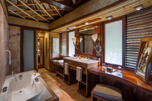 a bathroom with a tub and a sink at InterContinental Bora Bora Le Moana Resort by IHG in Bora Bora