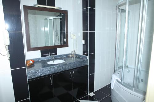 La salle de bains est pourvue d'un lavabo, de toilettes et d'un miroir. dans l'établissement Cihan Hotel, à Hopa