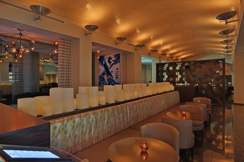 a restaurant with a bar with white chairs and tables at InterContinental At Doral Miami by IHG in Miami