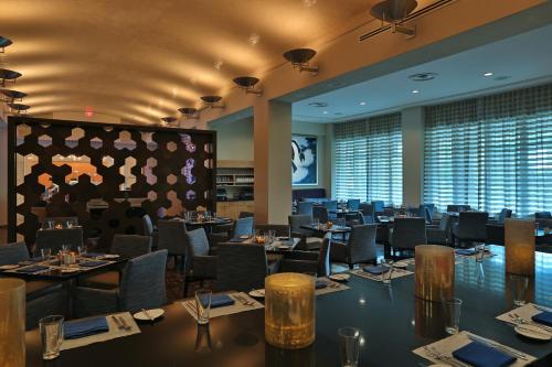 a restaurant with tables and chairs in a room with windows at InterContinental At Doral Miami by IHG in Miami