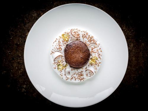a chocolate cake on a white plate on a table at InterContinental Bordeaux Le Grand Hotel by IHG in Bordeaux