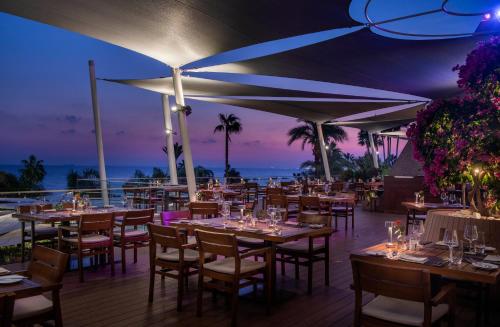 a restaurant on the beach at night with tables and chairs at Amathus Beach Hotel Limassol in Limassol