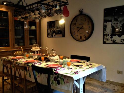 mesa de comedor con reloj en la pared en A Casa di Amelie, en Palermo