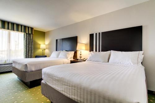 a hotel room with two beds and a window at Holiday Inn Express Hotel & Suites Live Oak by IHG in Live Oak