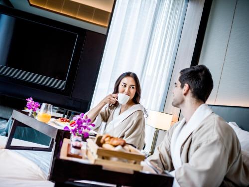 a man and woman sitting in a hotel room drinking coffee at InterContinental Singapore Robertson Quay by IHG in Singapore