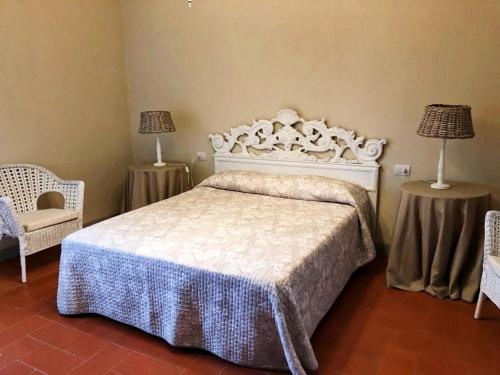 a bedroom with a bed and two chairs and two lamps at Agriturismo Il Principino in Vinci