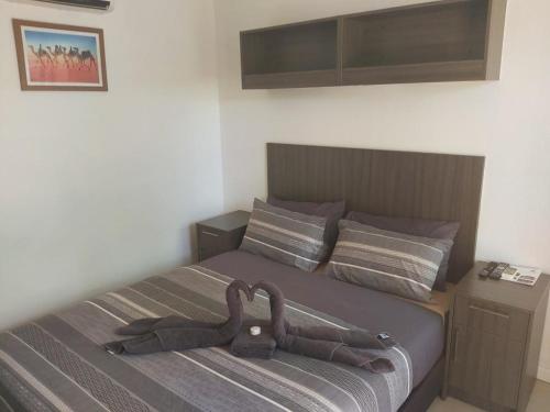 a bedroom with a bed with a brown head board at Capricorn Village in Newman