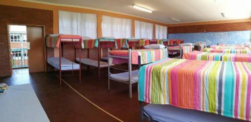ein Zimmer mit einem Haufen Betten und Stühlen in der Unterkunft Dirkie Uys Backpackers in Durban