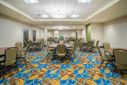a conference room with tables and chairs on a colorful carpet at Holiday Inn - Terre Haute by IHG in Terre Haute