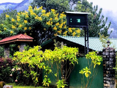 a house with a green gate with a clock on it at Hamadhi guest in Haldummulla