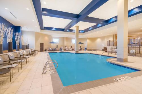 a pool in a hotel lobby with tables and chairs at Holiday Inn - Terre Haute by IHG in Terre Haute