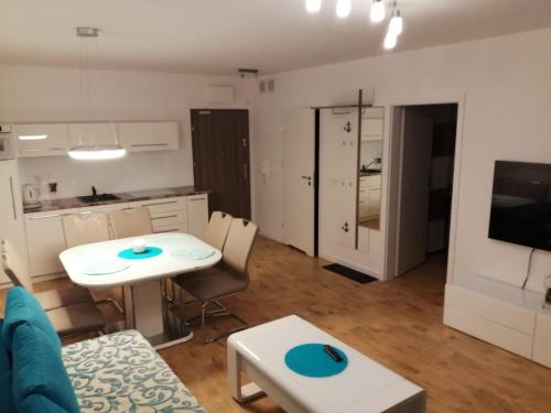 a kitchen and a living room with a table and chairs at Apartment LILY - Baltic Park Pogorzelica in Pogorzelica
