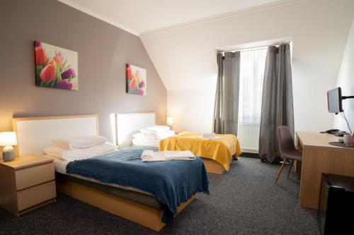 a hotel room with two beds and a desk at TeleDom Hotel in Košice