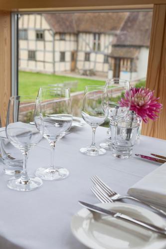 a table with wine glasses and a flower on it at Eckington Manor in Pershore