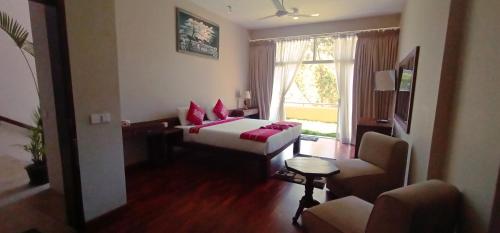 a hotel room with a bed and a couch and a window at Lilara Hills - Diyatalawa in Diyatalawa