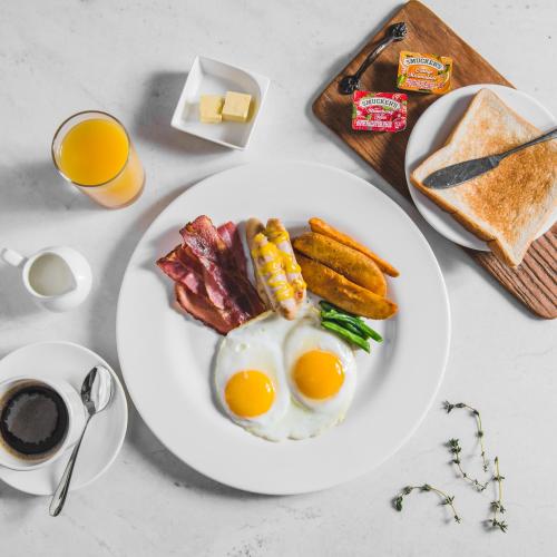 a white plate with eggs and bacon and toast at Skybay Hotel Gyeongpo in Gangneung