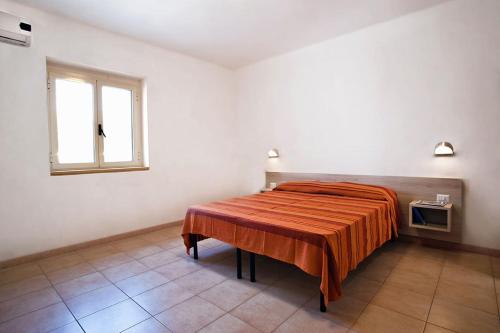 a bedroom with a bed with a orange blanket on it at Felicity Vieste in Vieste