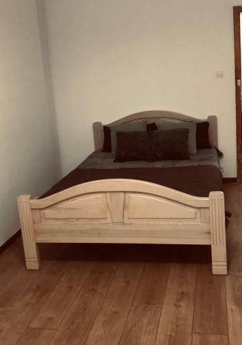 ein Bett mit einem Holzrahmen in einem Schlafzimmer in der Unterkunft Mazurska in Barczewo