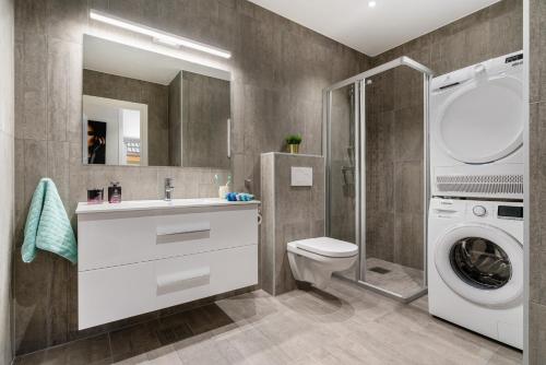 a bathroom with a toilet and a washing machine at Keyser Apartments 6 in Bergen