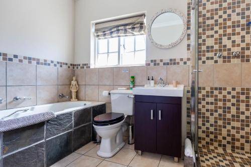 een badkamer met een bad, een toilet en een wastafel bij brookdale house in Kaapstad