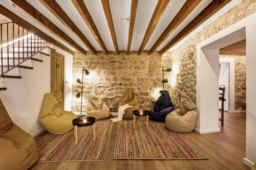 a living room with chairs and a stone wall at Hostel Sóller in Sóller