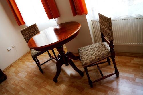 una mesa de madera y 2 sillas en una habitación en Penzion Aviatik, en Čáslav