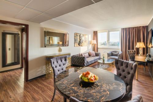 a living room with a table and chairs at Best Western Plus Plaza Hotel Darmstadt in Darmstadt