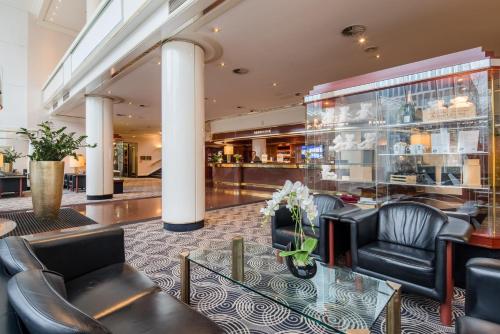 a lobby of a hotel with chairs and a table at Best Western Plus Plaza Hotel Darmstadt in Darmstadt