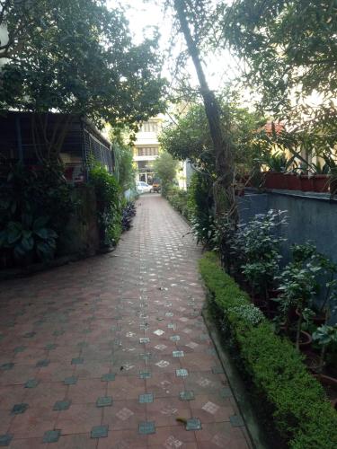 a brick path with trees and a building in the background at Sandra's Home in Ernakulam