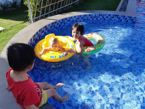 two young children playing in a swimming pool at AnAn Boutique Bungalows with Private Kitchen in Phu Quoc