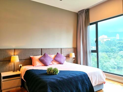 sypialnia z łóżkiem z fioletowymi poduszkami i oknem w obiekcie ELECTUS HOME at Vista Residences Genting - FREE WiFi & TV Box & Parking w mieście Genting Highlands